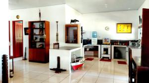 ein Wohnzimmer mit einer Küche mit einer Spüle und einer Theke in der Unterkunft Casa em Soure Ilha de Marajó. in Soure