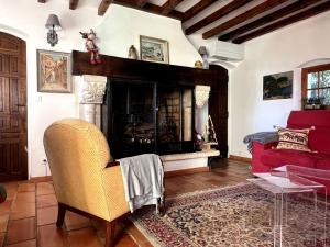 - un salon avec une cheminée et un canapé rouge dans l'établissement Joli mas "Rêve de lune" en plein coeur du Luberon, à Roussillon