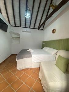 Habitación con 2 camas y sofá. en Casita Gazul, en Alcalá de los Gazules