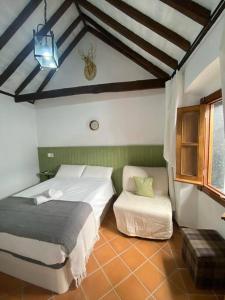 Un dormitorio con 2 camas y una silla. en Casita Gazul, en Alcalá de los Gazules