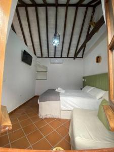 Habitación con 2 camas y sofá. en Casita Gazul, en Alcalá de los Gazules
