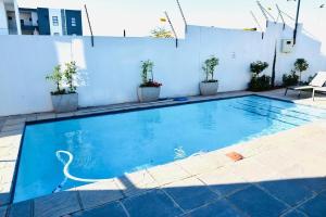 a blue swimming pool with a white wall at On New Luxury stay 2 WITH BACK UP POWER in Midrand