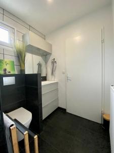 a bathroom with a white toilet and a sink at Appartement terrasse proche Versailles in Élancourt