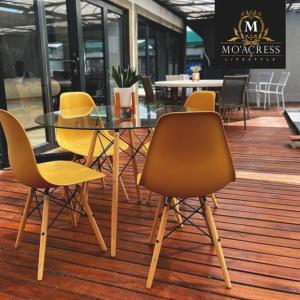 einen Tisch mit gelben Stühlen, einem Glastisch und Stühlen in der Unterkunft Mo'Acress Lifestyle 