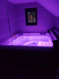 un baño púrpura con jacuzzi en una habitación en Holiday house Nune, en Zreče