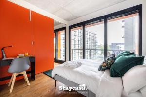 a bedroom with orange walls and a bed and a desk at Luxury Haven Double Balcony Apt With Canal View in Manchester