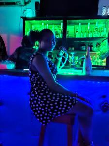 a woman sitting in a chair at a bar at Big Apple Hotel in Montego Bay