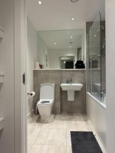 y baño con aseo, lavabo y ducha. en Spacious 2 Bedroom Flat With Balcony, en Barking