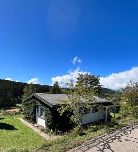 une petite maison sur le côté d'une route dans l'établissement Haus im Schwarzwald, à Lenzkirch