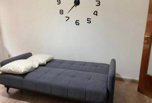 a clock on a wall in a room with a couch at Monteverde relax house in Rome