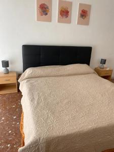uma cama num quarto com duas mesas de cabeceira e duas fotografias na parede em Monteverde relax house em Roma