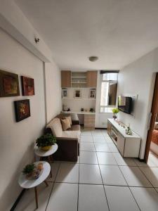 a living room with a couch and a kitchen at Aconchegante apart no Park Sul in Brasília