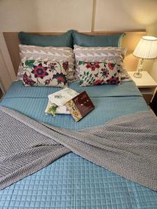 a blue bed with a book and pillows on it at Aconchegante apart no Park Sul in Brasília