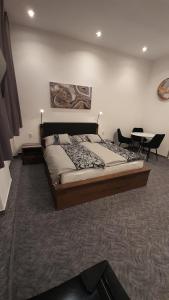 ein Schlafzimmer mit einem großen Bett und einem Tisch in der Unterkunft Penzion U Bernardýna in Tachov