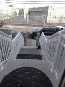 a stairway with white railings and a car in a parking lot at Dayton Dream in Newark