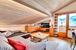 ein Wohnzimmer mit einem Sofa und einem Tisch in der Unterkunft Stilvolle 2.5 Zimmer Wohnung nähe Skigebiet in Savognin