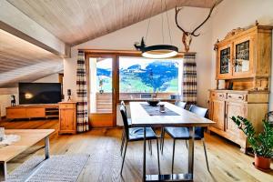 ein Esszimmer mit einem Tisch, Stühlen und einem TV in der Unterkunft Stilvolle 2.5 Zimmer Wohnung nähe Skigebiet in Savognin