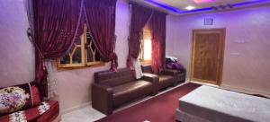 uma sala de estar com cortinas roxas e um sofá em Riad Khadija: Relax & Explore em Taroudant