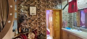 a bathroom with a sink and a clock on the wall at Riad Khadija: Relax & Explore in Taroudant