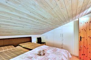 Schlafzimmer mit einem Bett mit Holzdecke in der Unterkunft Stilvolle 2.5 Zimmer Wohnung nähe Skigebiet in Savognin