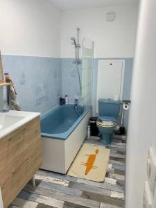 a bathroom with a blue tub and a toilet at Charment Appartement Duplex - Pornichet in Pornichet