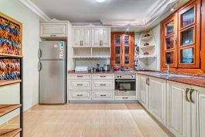 a kitchen with white cabinets and a stainless steel refrigerator at Two Seas Villa in Alanya