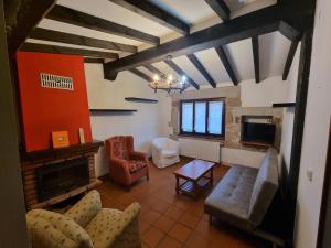 - un salon avec un canapé et une cheminée dans l'établissement La Jomeruca ,espaciosa casa rural cerca de playa y montaña, à Carranceja