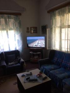 een woonkamer met twee blauwe banken en een tv bij Lanina kuca 