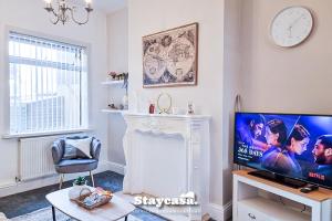 sala de estar con TV y chimenea en Modern Comforts In Ne Lincolnshire Entire Home, en Grimsby