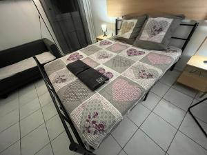 a bed with a quilt and a purse on it at Casanova home in Saint-Denis