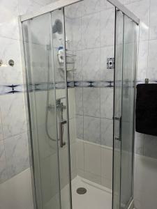 La salle de bains est pourvue d'une douche avec une porte en verre. dans l'établissement Casanova home, à Saint-Denis