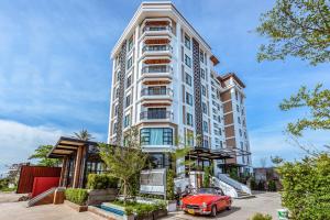 an apartment building with a red car in front of it at S Park Design Hotel in Vientiane