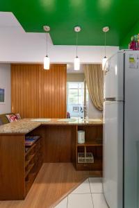 a kitchen with a white refrigerator and a green ceiling at Studio SOL de COPACABANA 300 m da Praia in Rio de Janeiro
