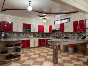 una cucina con armadi rossi e ripiani in marmo di Villa de l'ermitage a Imsouane