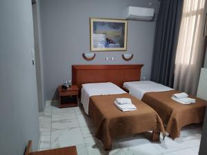 a bedroom with two beds with towels on them at Piraeus Acropole Hotel in Piraeus