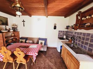 a kitchen with a table and a cross on the wall at Stateček plný zvířátek 