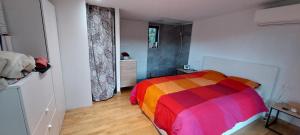 a bedroom with a colorful bed in a room at Cocon tout confort au coeur de la nature in Carnoules