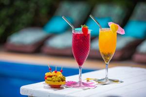 twee cocktails en een fruitschaal op een tafel bij Pousada Jardim Das Margaridas in Trancoso
