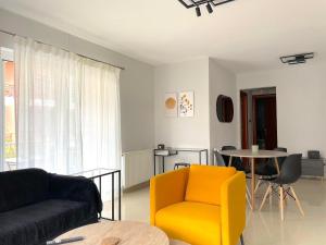 Anatolí的住宿－Διαμέρισμα υψηλής αισθητικής，客厅配有黄色椅子和桌子