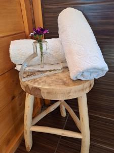 a vase of flowers sitting on a stool with a table at Wooden House at the Mountain-private in Paránimfoi