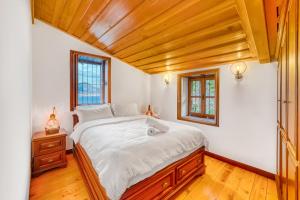 una camera con un grande letto e un soffitto in legno di The Sukabaği House a Alanya