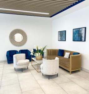 a living room with a couch and chairs and a mirror at Urban Gateway Spacious Apartment with free parking in Bracknell