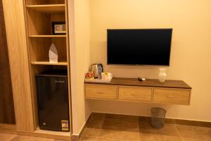 a room with a television and a small refrigerator at Blue Pyramids Eyes Hotel in Cairo