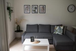 - un salon avec un canapé et une table dans l'établissement Green Oasis Apartment, à Alexandroúpolis