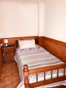 um quarto com uma cama com uma estrutura em madeira em Tifrys em La Serena