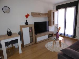 a living room with a flat screen tv and a table at La Encina in Lerma