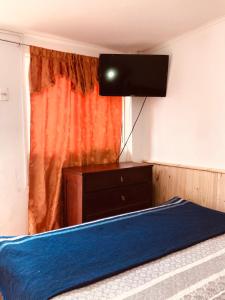 a bedroom with a bed and a flat screen tv at Tifrys in La Serena
