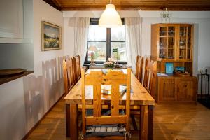 Ferienhaus Smultronsställe Hjo, Vättern في هيو: غرفة طعام مع طاولة وكراسي خشبية