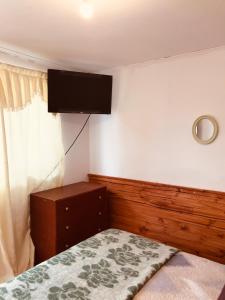 a bedroom with a bed and a flat screen tv on the wall at Tifrys in La Serena