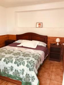 a bedroom with a bed with a green and white comforter at Tifrys in La Serena